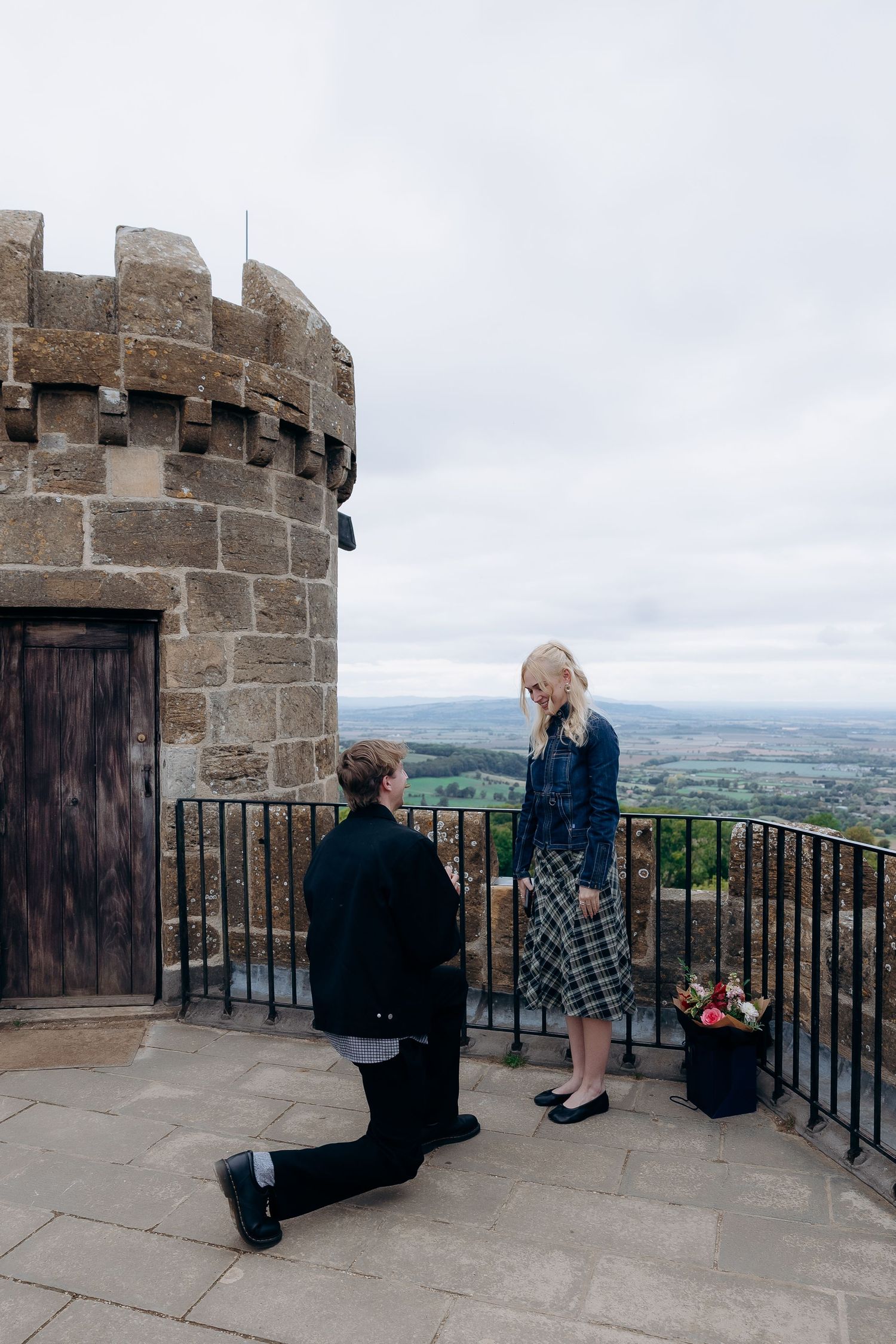 Couple walking around Broadway Tower after their engagement.