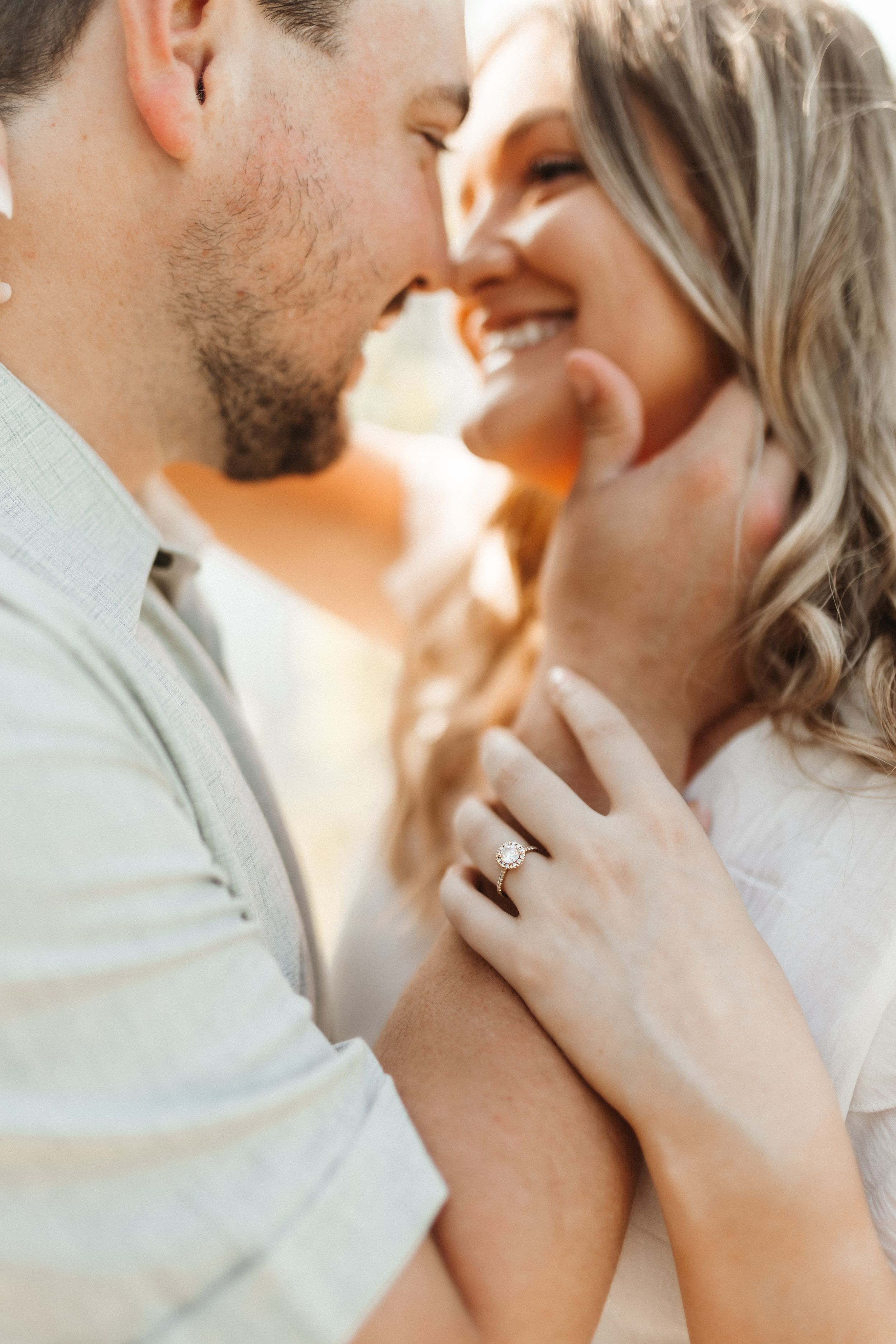 Romantic close-up portrait of couple sharing intimate moment with warm lighting and soft focus.