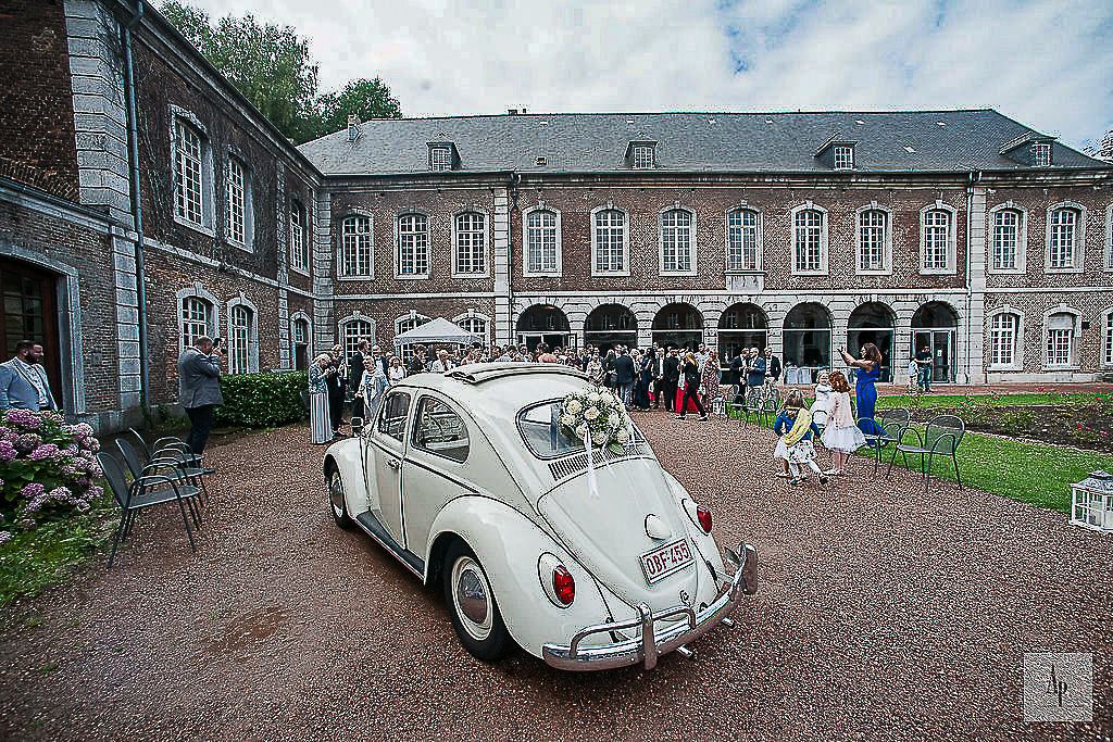 Couple de mariés dans une Coccinelle ancienne à l'abbaye d'Aulne
