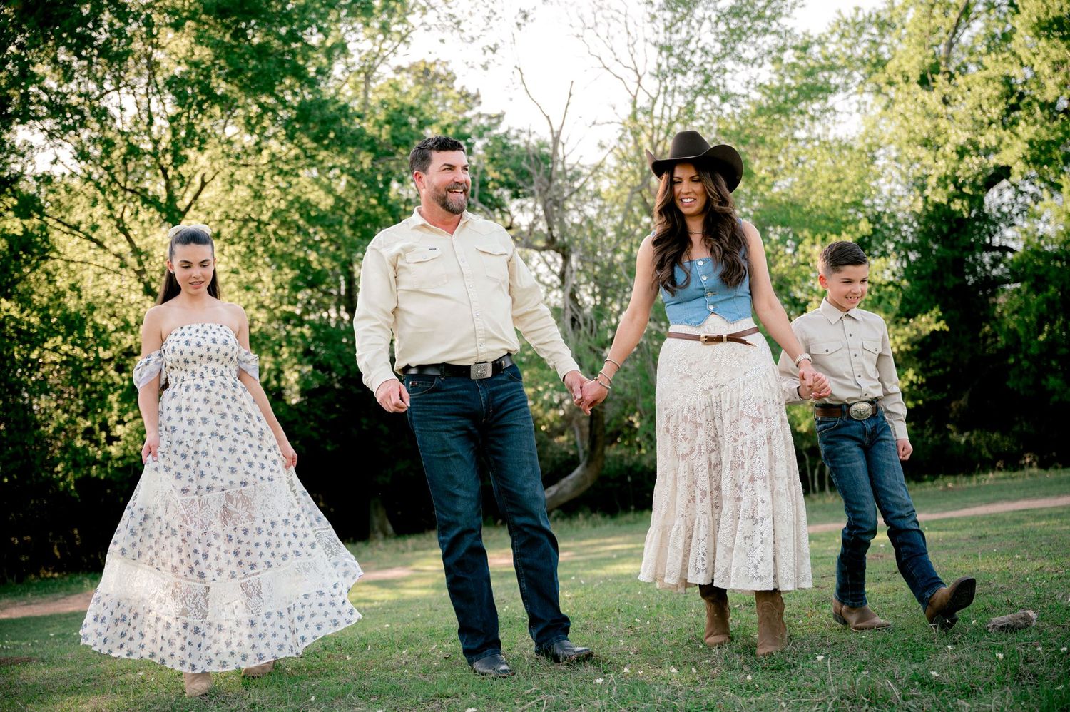 Family holding hands and walking together amidst a farm in Tomball, Texas.
