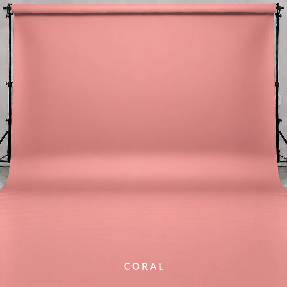 Coral pink seamless paper photography backdrop displayed on a studio backdrop stand system.