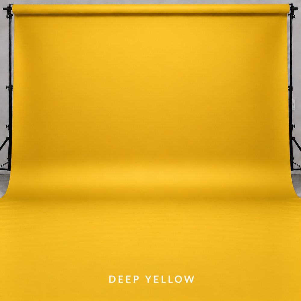 Deep yellow seamless paper backdrop on professional photography stand, perfect for vibrant studio portrait backgrounds.