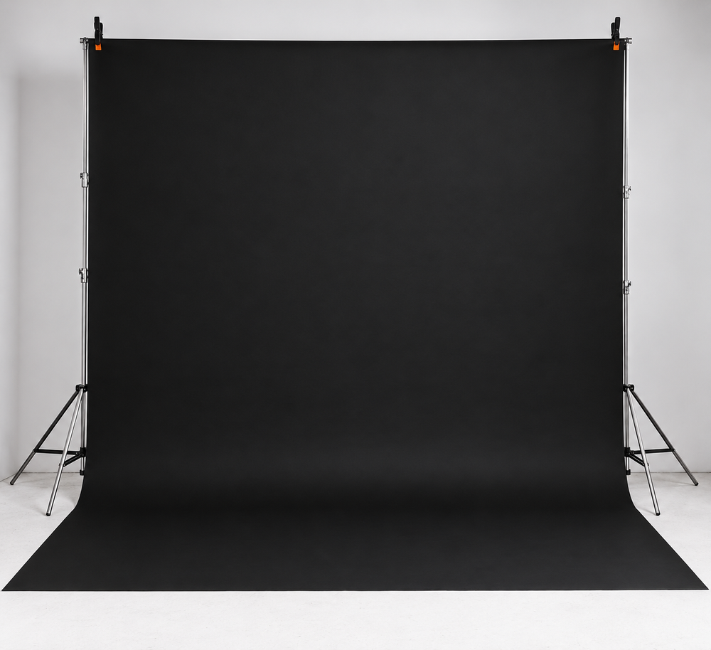 Professional black photography backdrop on adjustable stand, ideal for studio portrait and product photography sessions.