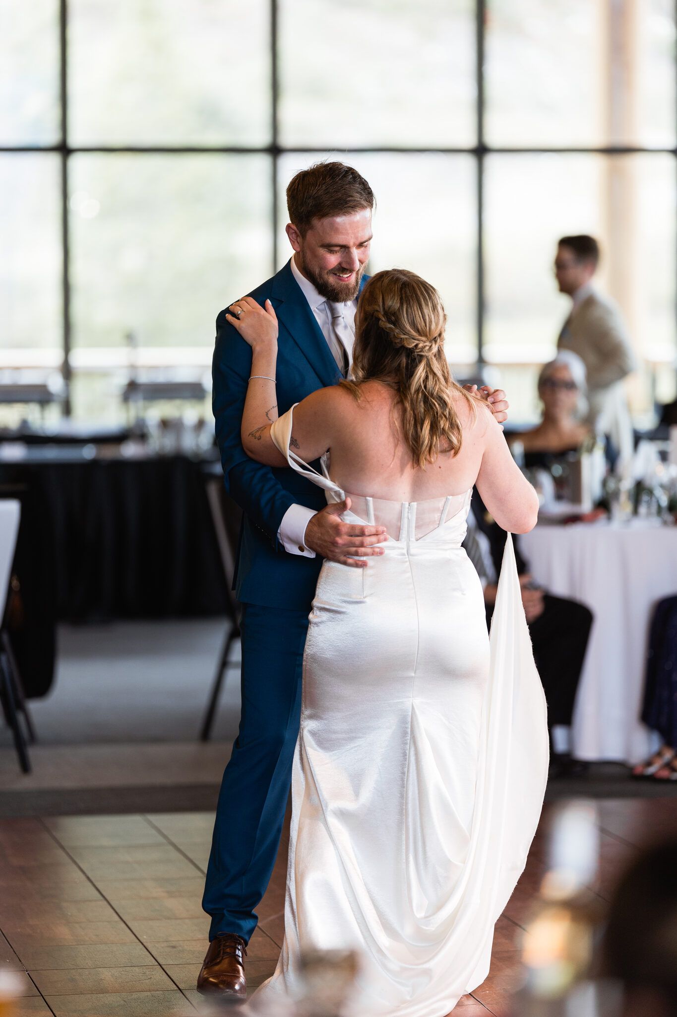 Newlyweds dancing beside floor-to-ceiling windows at Vista Canmore wedding reception
