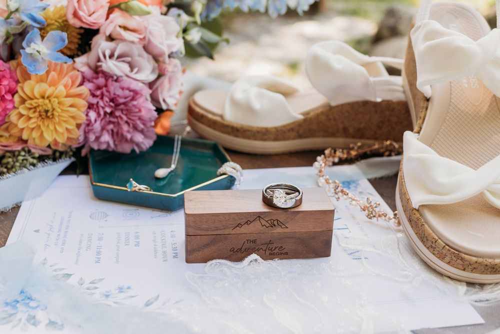 Wedding invitation suite arranged with rings and bridal accessories.