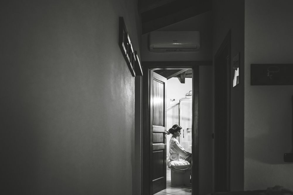 La sposa in controluce sulla soglia, in bianco e nero.
