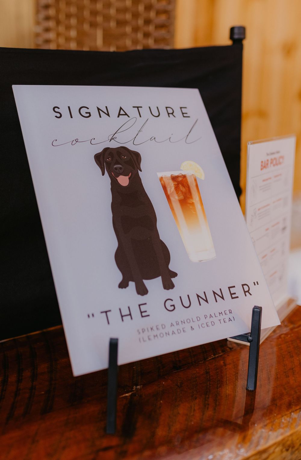 Signature cocktail sign featuring a black Labrador dog and The Gunner spiked Arnold Palmer drink at a wedding bar.