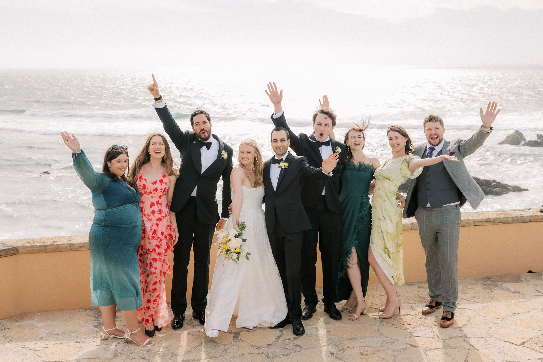 Bride and groom celebrating with their closest friends overlooking the Atlantic Ocean after their destination wedding ceremony at Arriba by