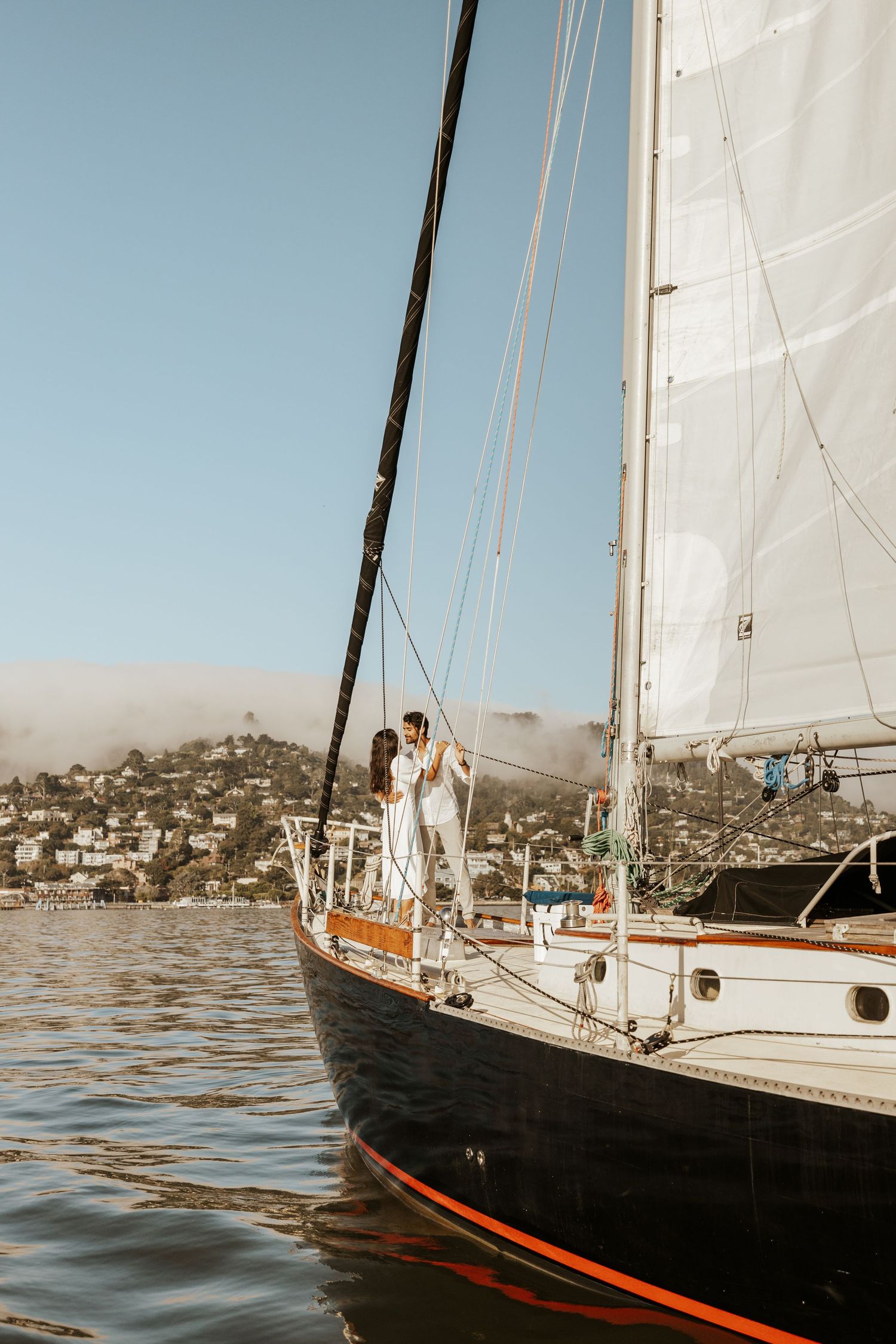 couple on the bow of a sailboat in sausalito. san francisco bay area engagement photographer