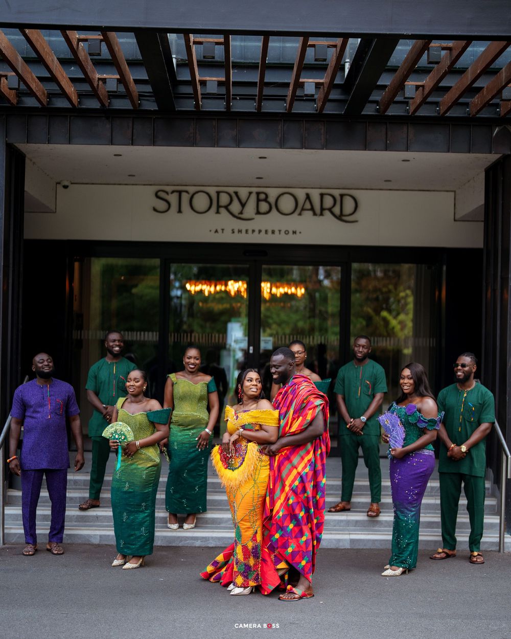 Wedding party in colorful African attire poses outside Storyboard at Shepperton venue.