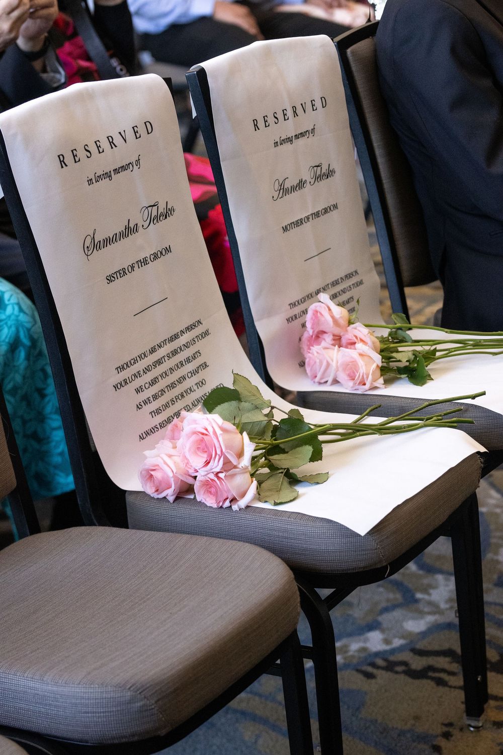 Reserved memorial chairs with pink roses honoring deceased loved ones at wedding.