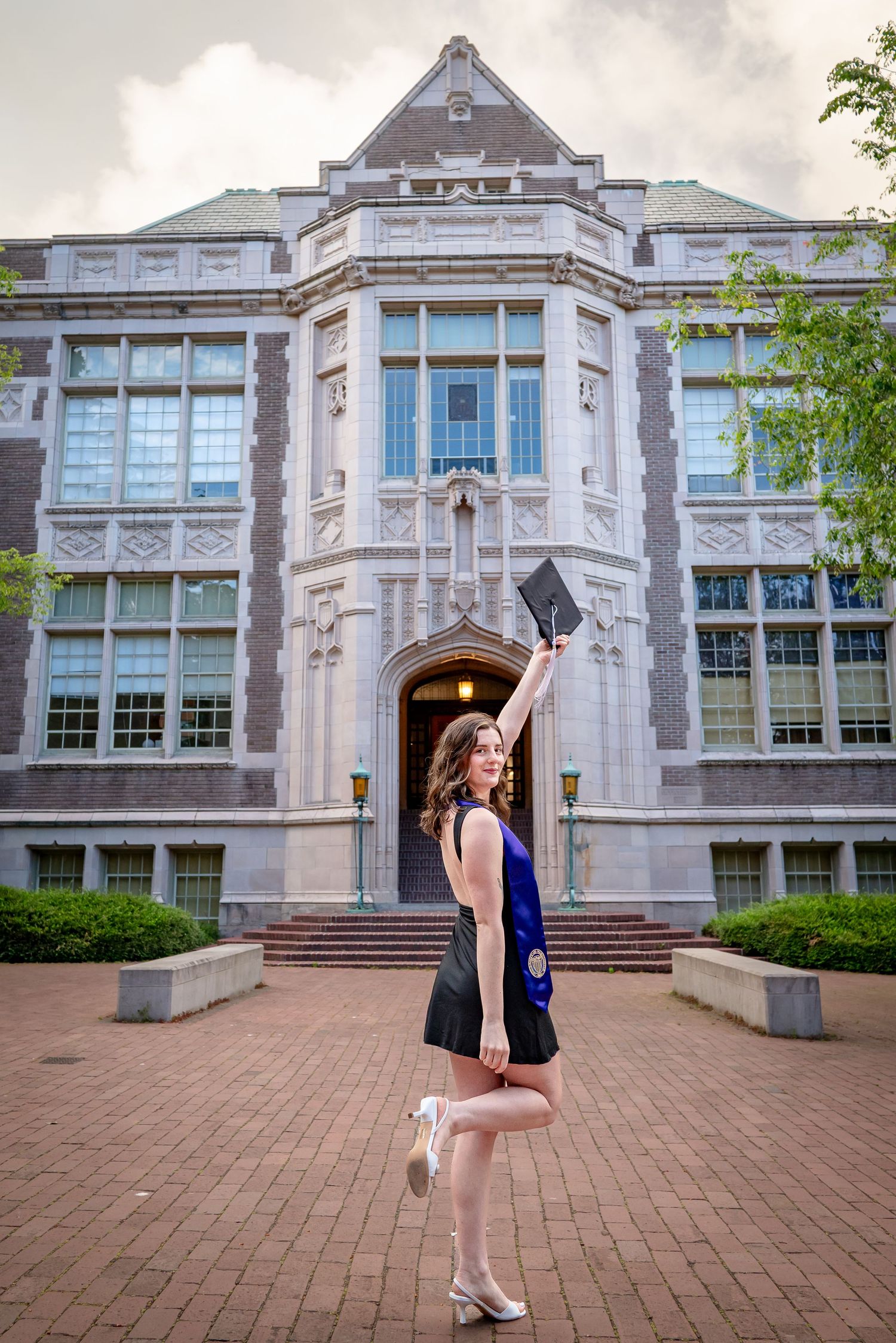 University of Washington graduate posing in front of historic Raitt Hall
