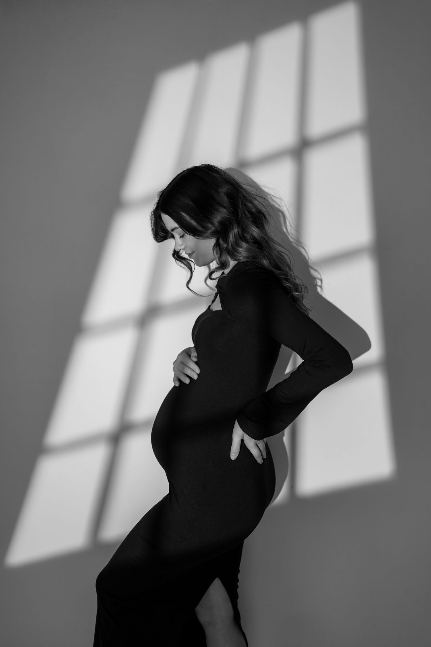 A dramatic black and white photo series showing a person in shadow against a wall with light streaming through windows.