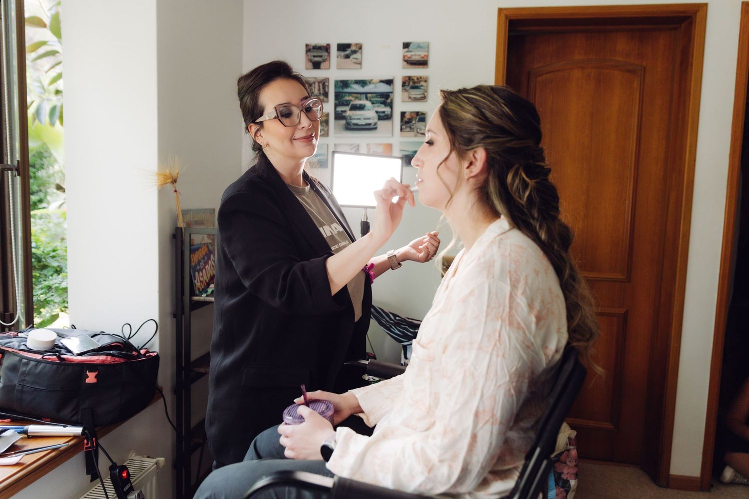 Professional makeup artist working on bride's look before the wedding ceremony.