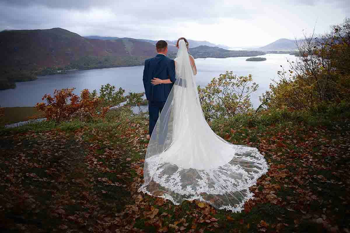 bride and groom look out over surprise view above lodore falls hotel and spa wedding venue in Keswick, the lake district
