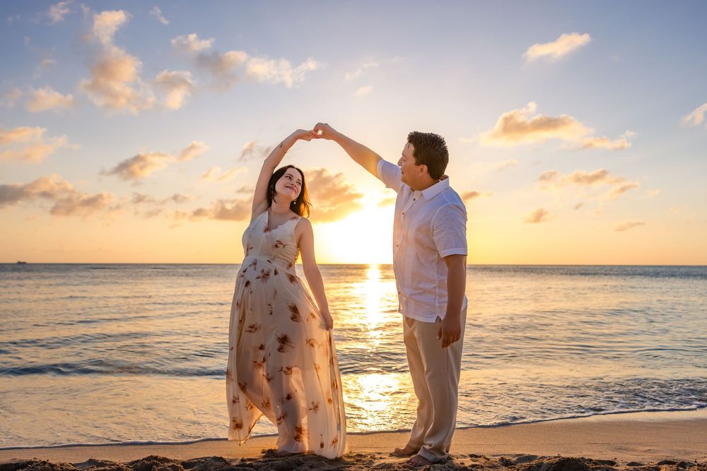 Couple embracing during a sunset beach maternity pregNancy session in Cozumel
