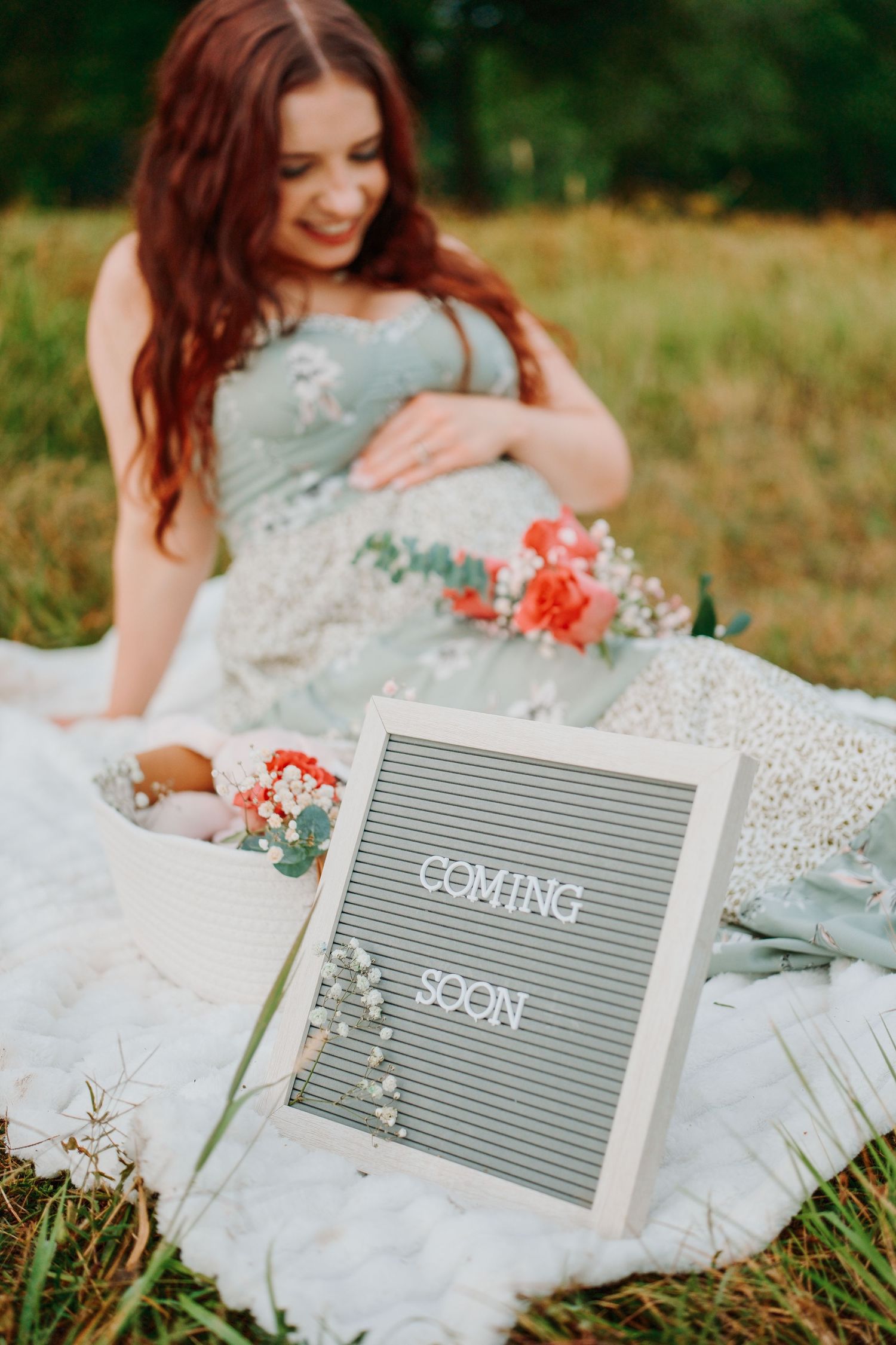 Embroidery hoop with floral design and name Lorelai Joyce beside ultrasound photos and a baby onesie with fruit print.