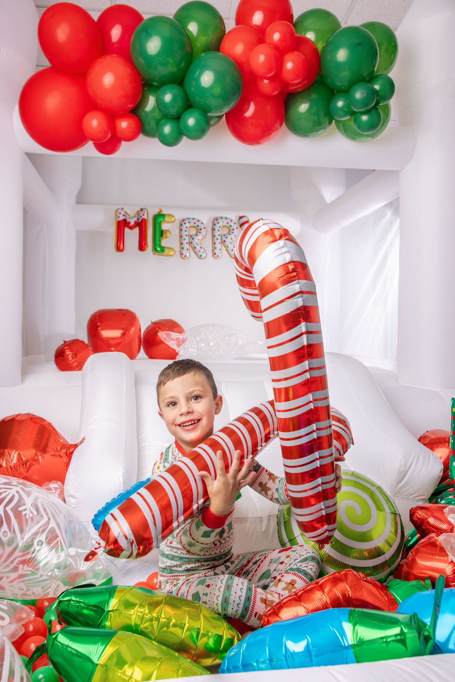 Colorful party banner that says 'ME' with red and green polka dots and a striped ball decoration against white background.