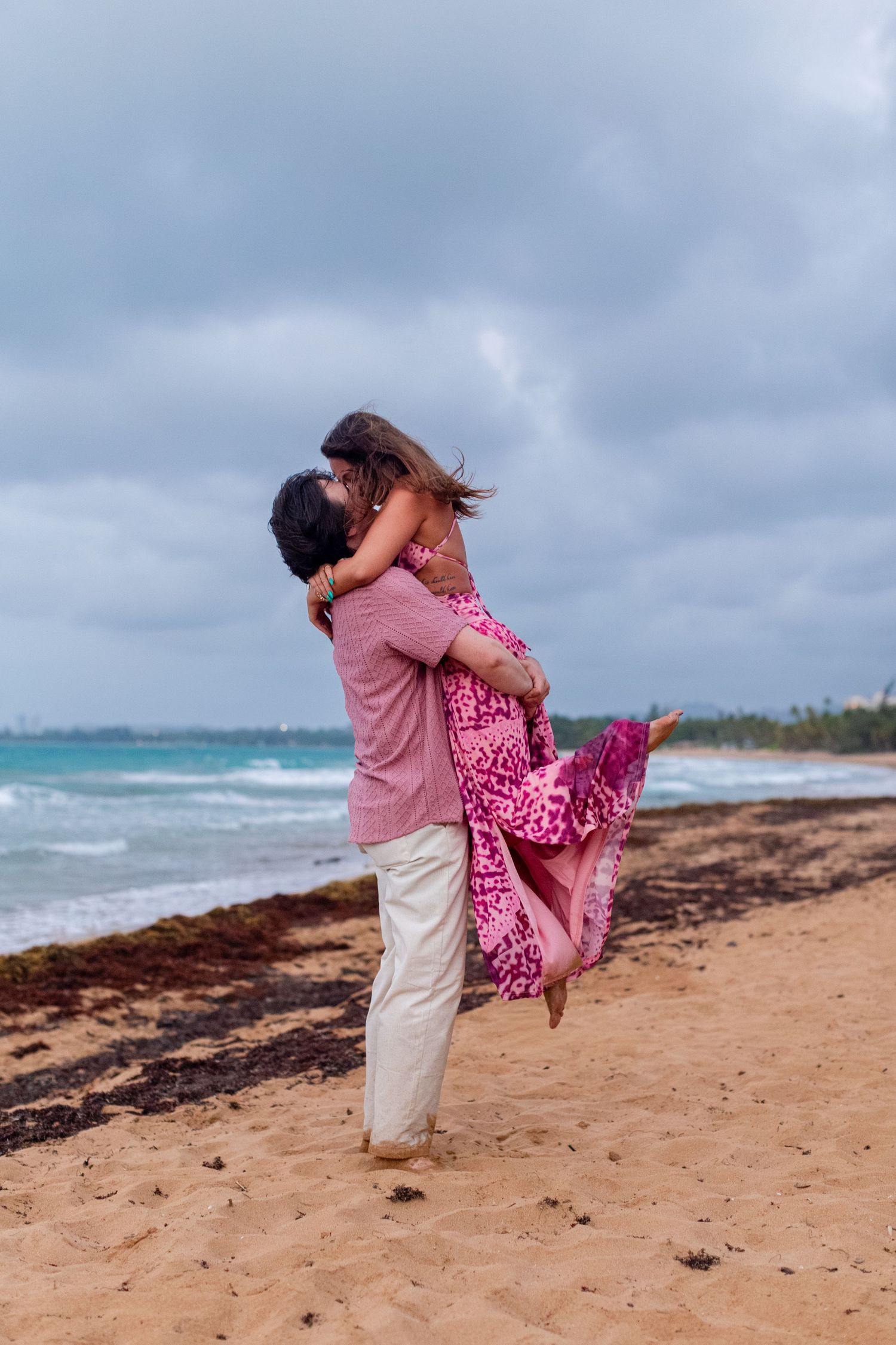 Couples portrait on the beach. Man picking up the woman. Río Grande, Puerto Rico.