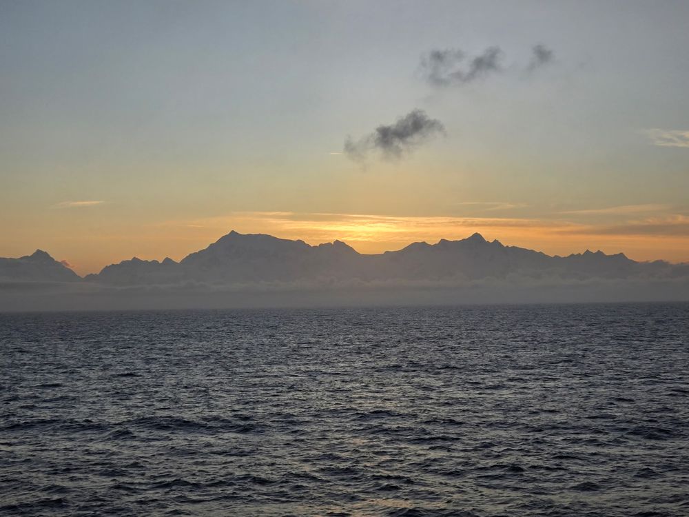 Peaks of the Fairweather Range rising directly out of the ocean, as seen from the waters of Glacier Bay or the Icy Strait corridor.