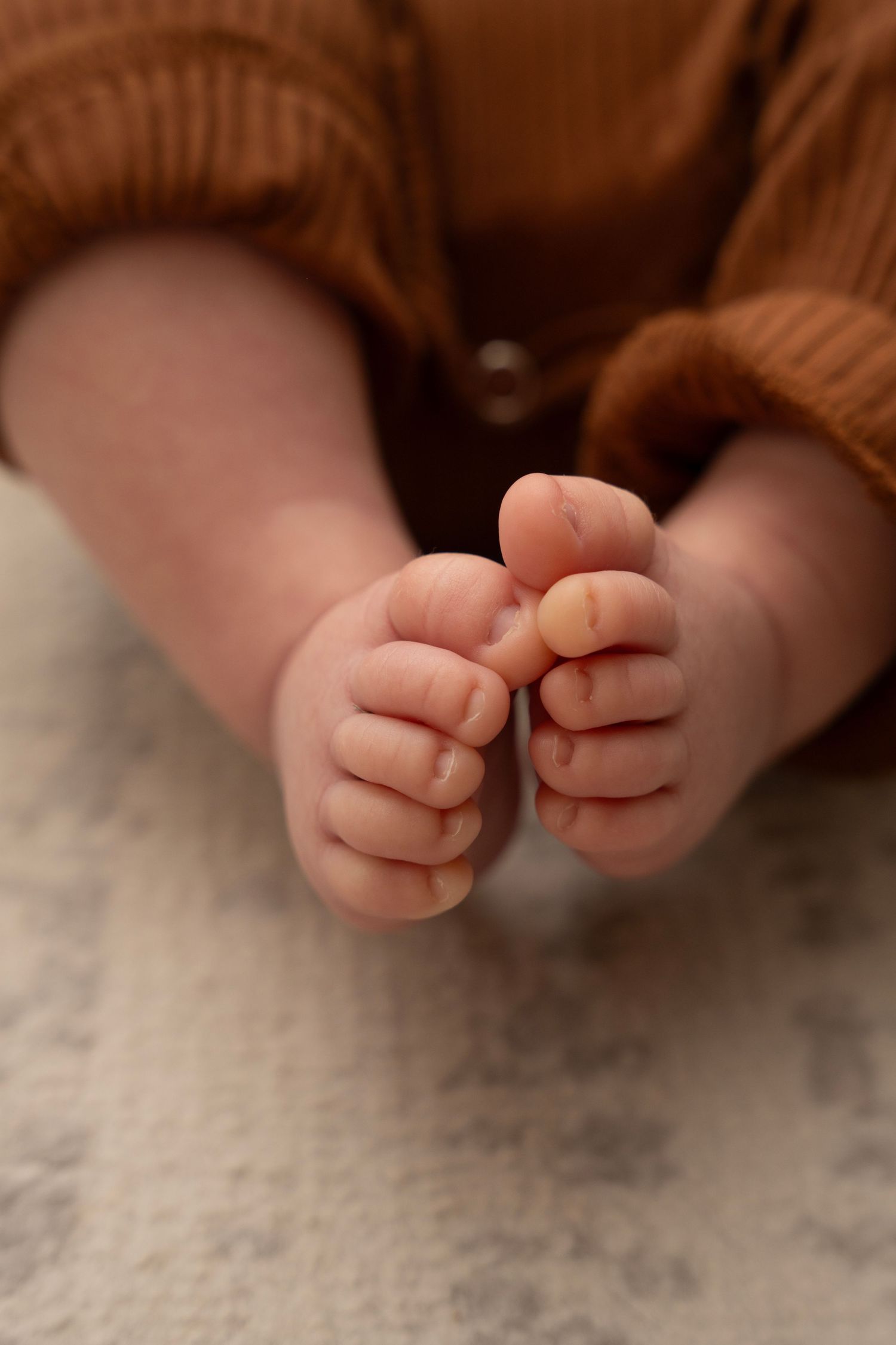Close up of tiny baby feet against soft textured background at newborn photoshoot in Wilmette