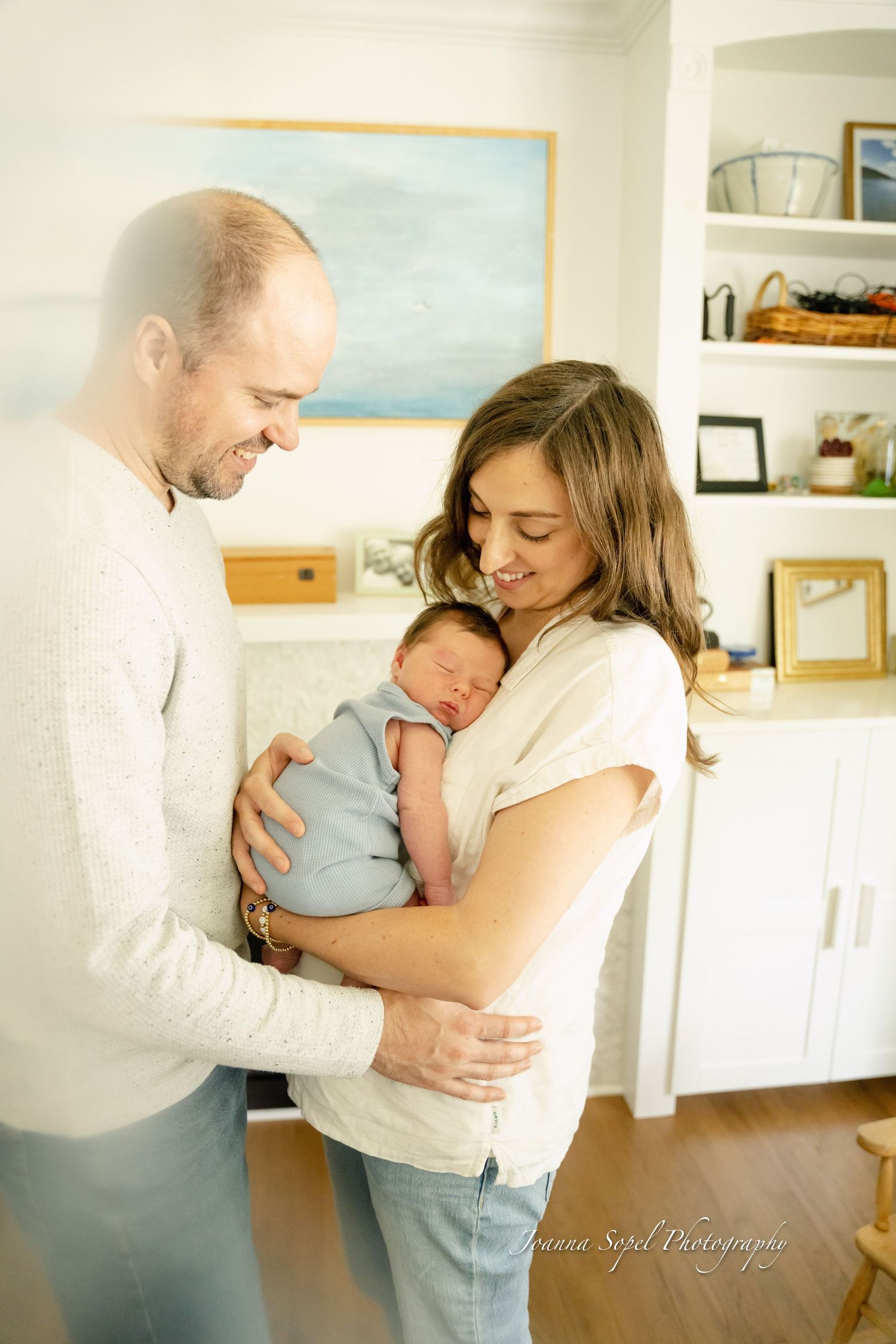 A loving family moment captured in a series of tender embraces in a bright, airy home setting during newborn session in Mount Prospect