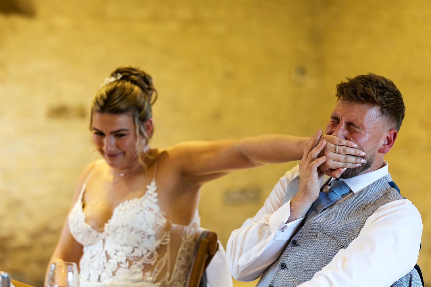 Bride and groom sharing a romantic moment in sunlit doorway surrounded by lush greenery on their wedding day.