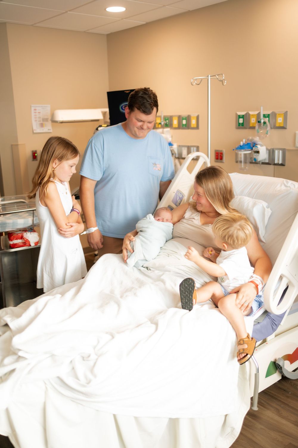 Family gathered around mother in hospital bed meeting their newborn baby at Parkwest Medical Center in Knoxville, TN.