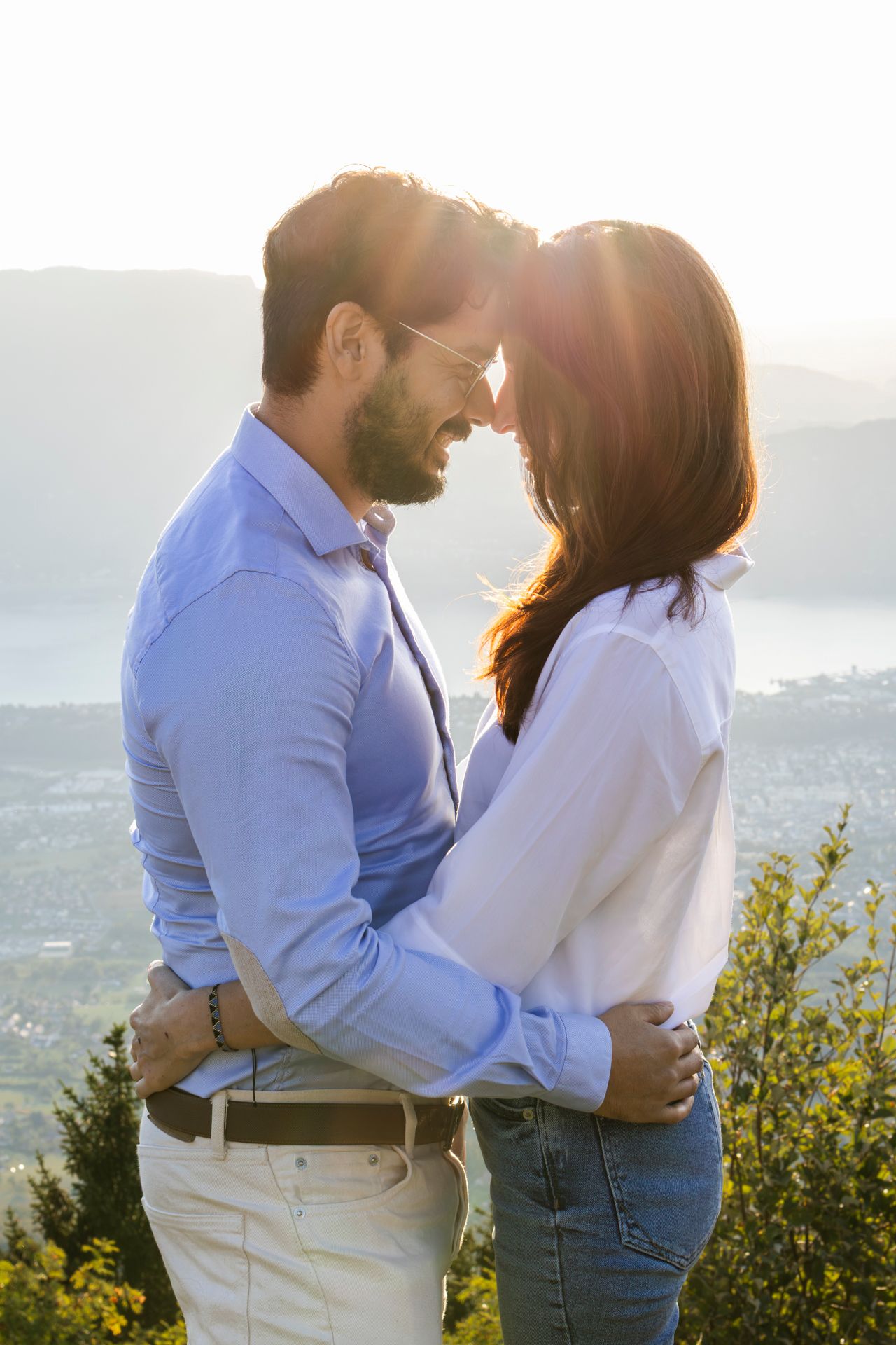 Couple front contre front, enlacé dans la lumière dorée du soir, séance photo de couple en Savoie