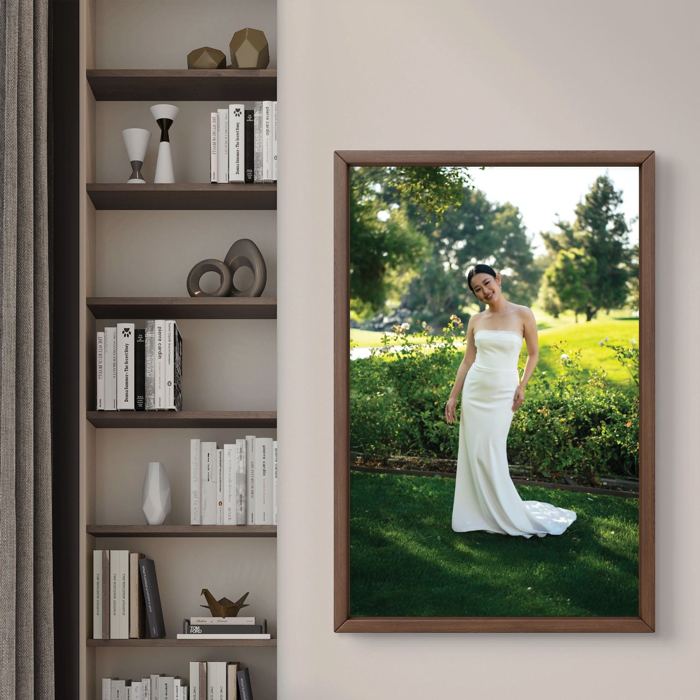 Elegant bride in white gown displayed in a large framed photo on a living room wall beside a bookshelf.