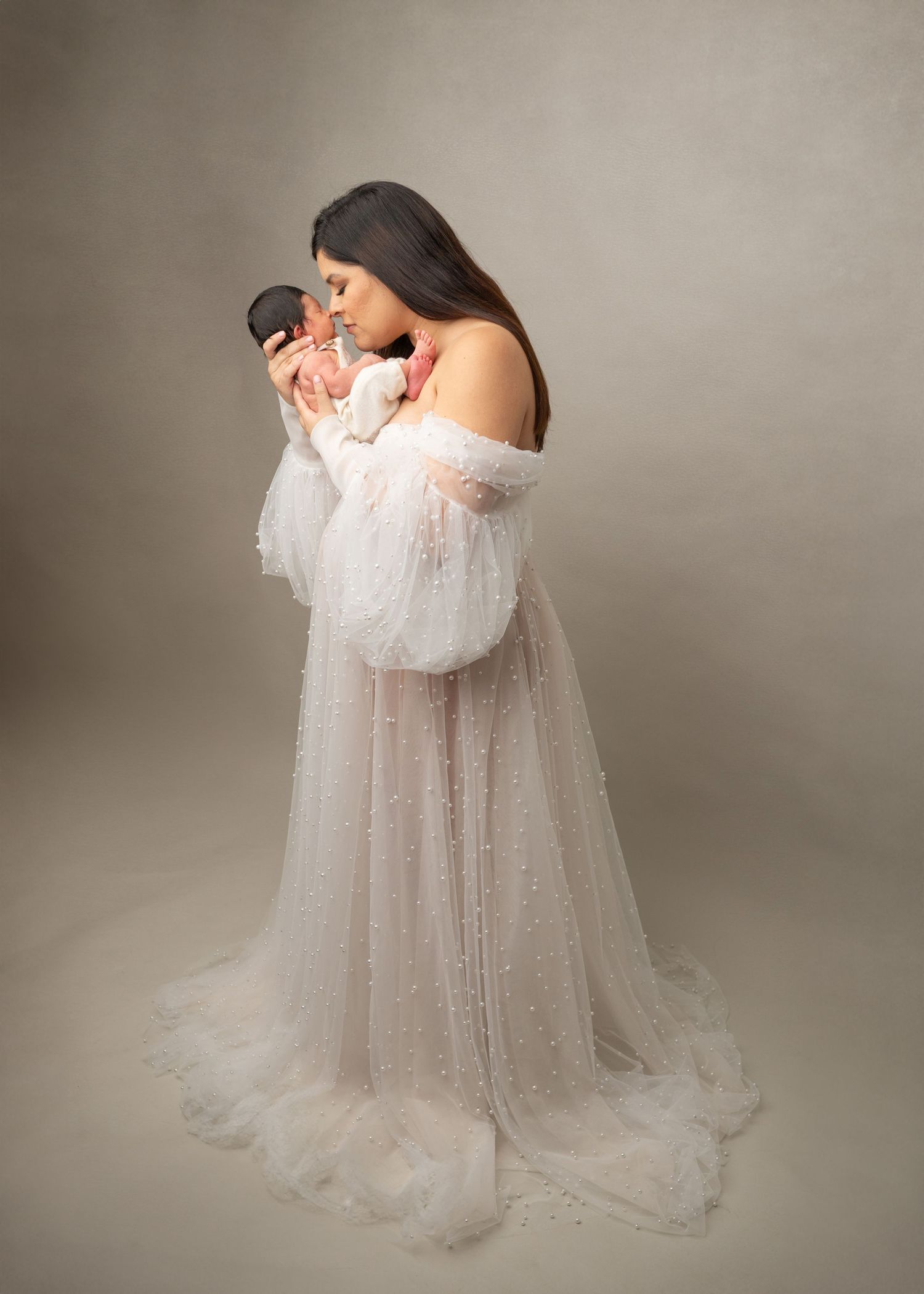 Mom wearing a pearl gown cuddling her baby in a new jersey studio