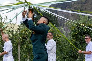 Un marié en Suisse photographié entrain de faire l'animation de la bouteille.