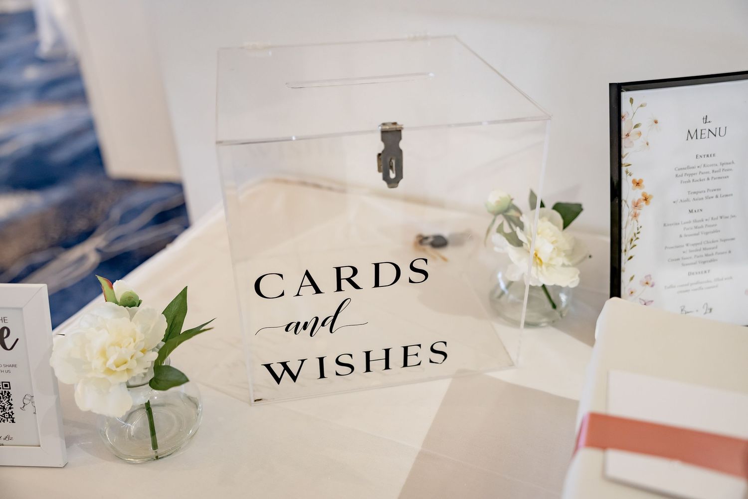Elegant wedding card box with Cards and Wishes sign, white peonies, and acrylic display on decorated table.