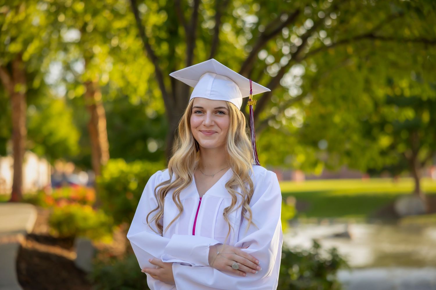 Senior girl wearing cap and gown in white