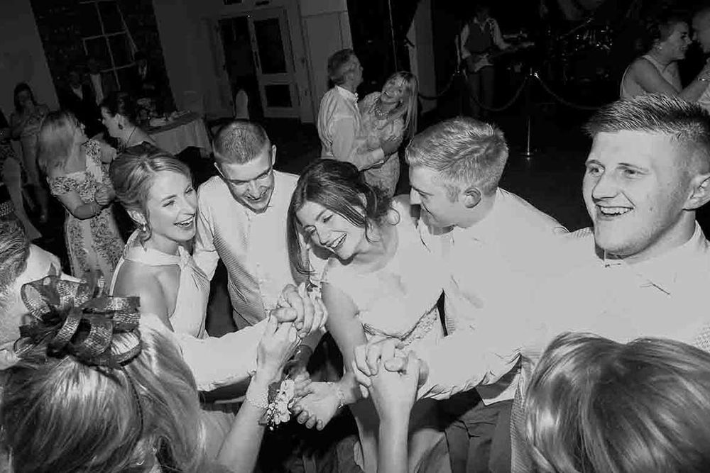Black and white photo of the Bride & Groom joyfully dancing together at a wedding reception celebration at Greenhill Hotel near Wigton