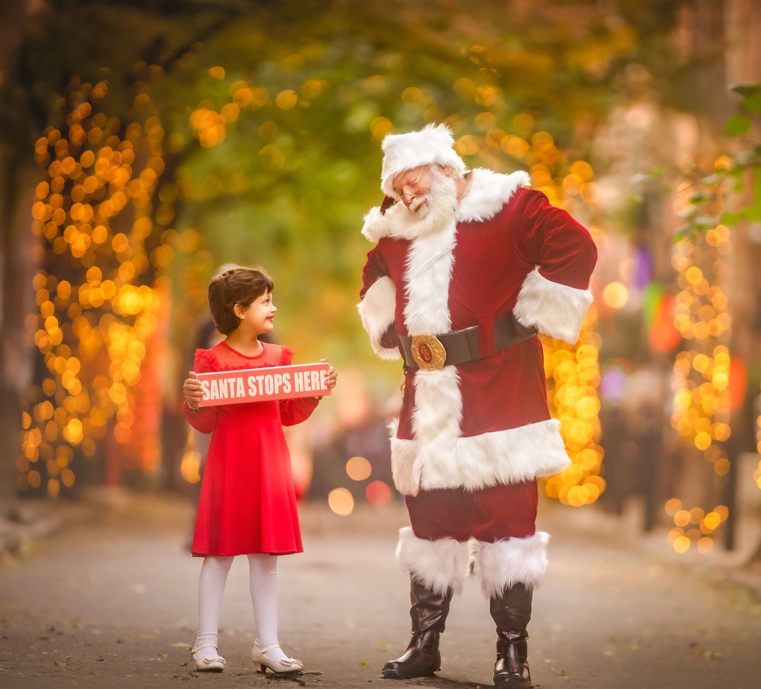 Santa Claus and young girl smiling together during a Christmas photo session in South Jersey.