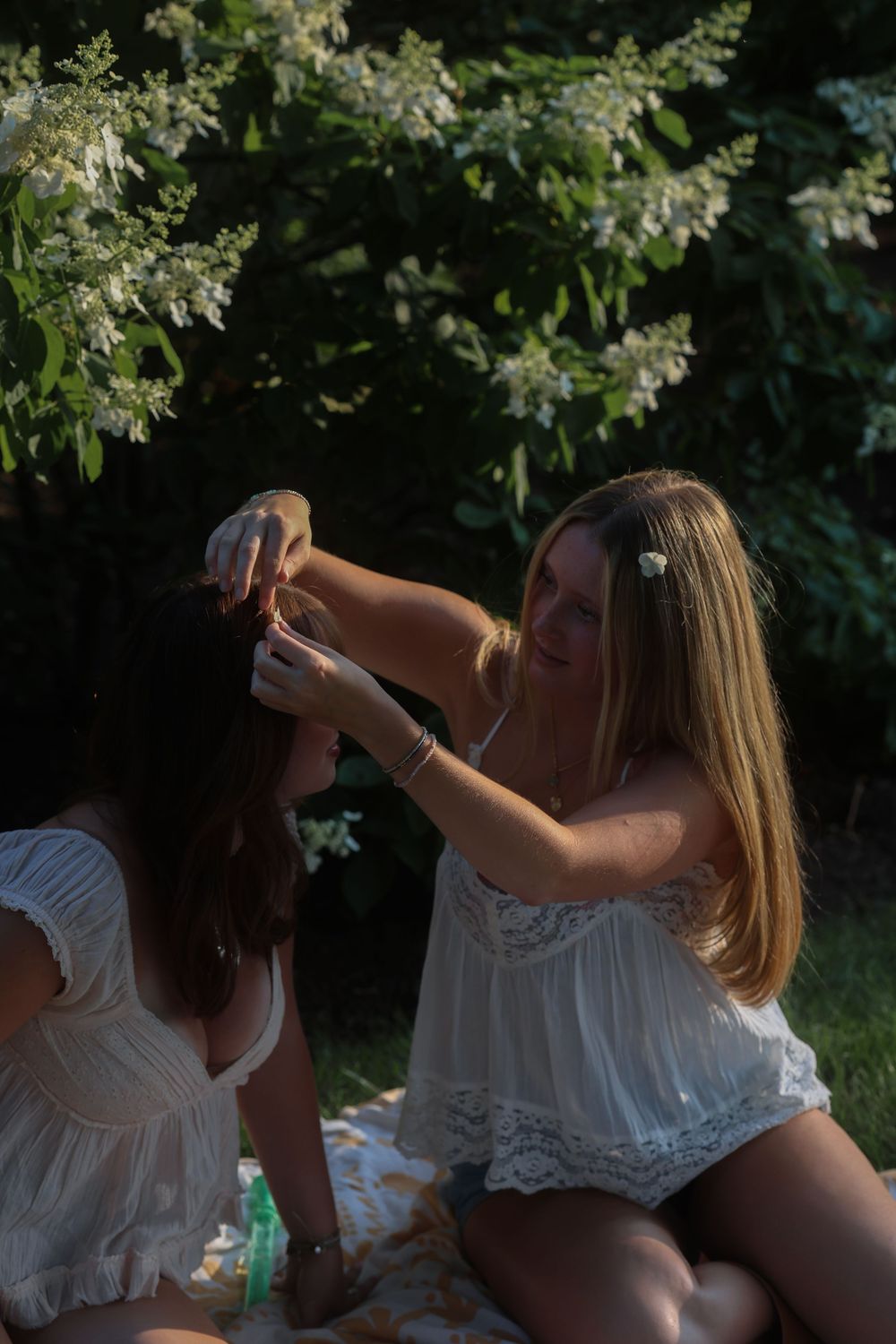 Woman placing a flower in her friend's hair