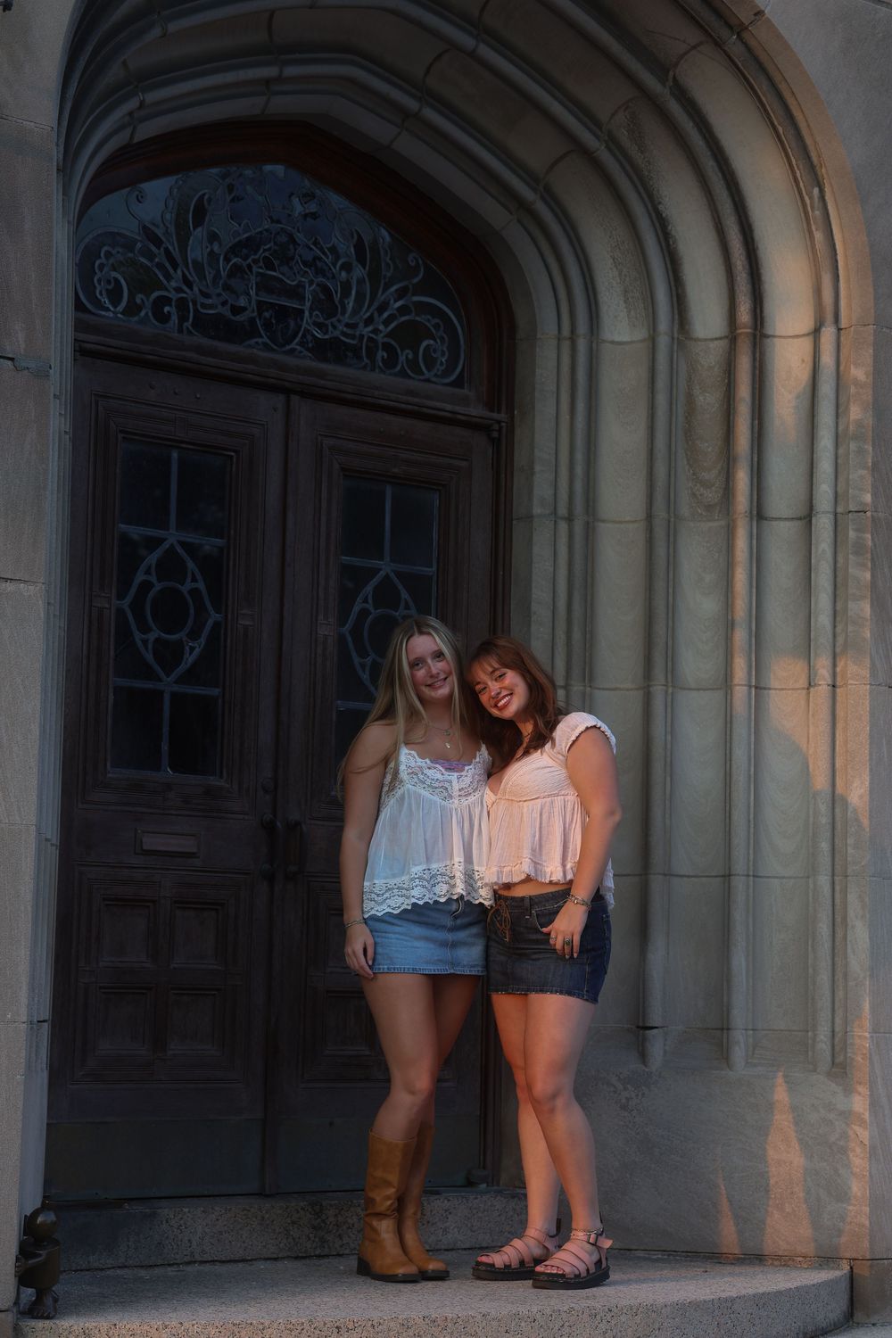 Two women posing in front of a building