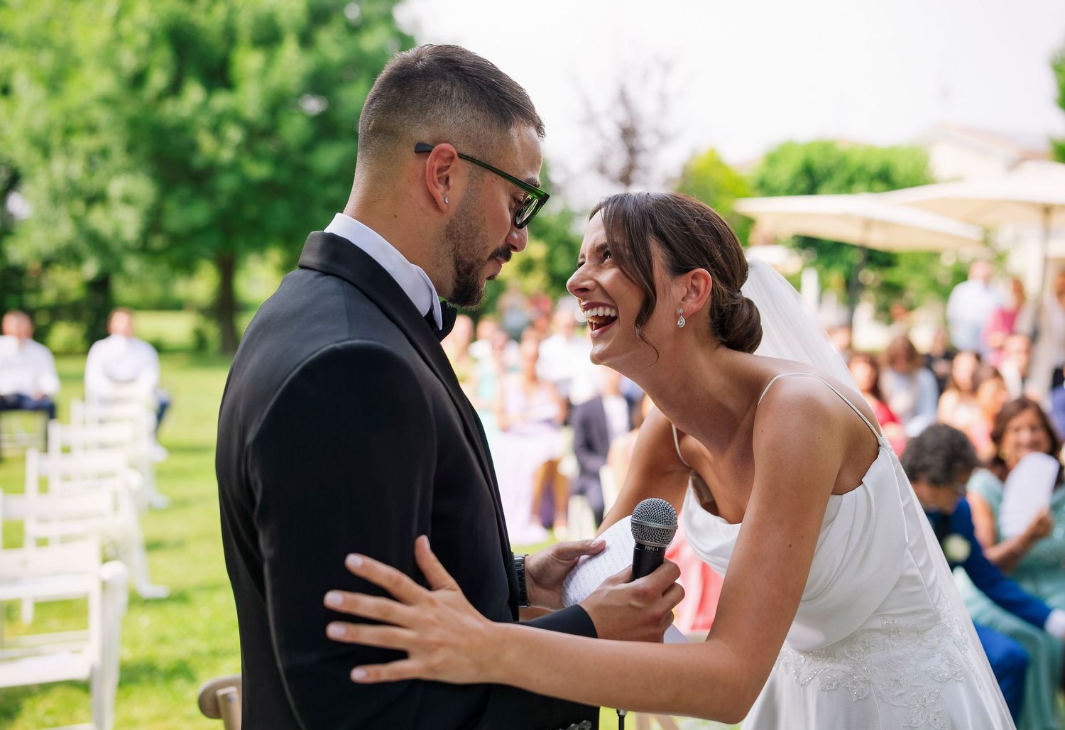 Sposi si guardano sorridendo durante la cerimonia all’aperto