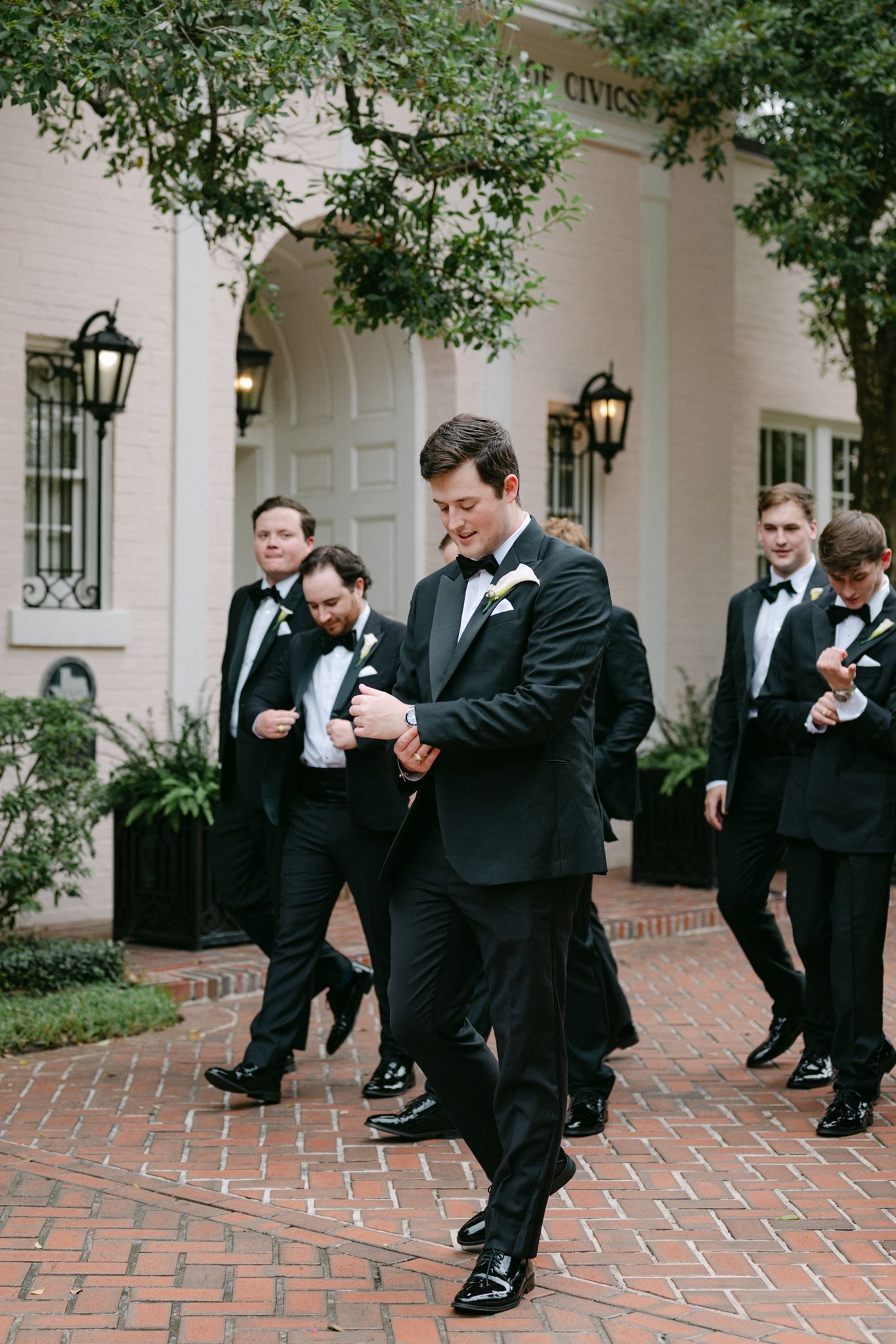 Groom and groomsmen walking towards the garden ceremony at the River Oaks Garden Club in Houston Tx.