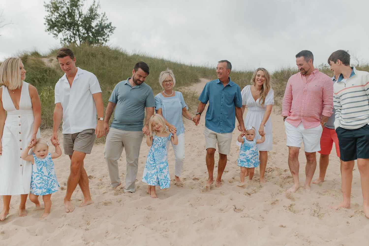 A group walking together along a sandy beach at sunset.