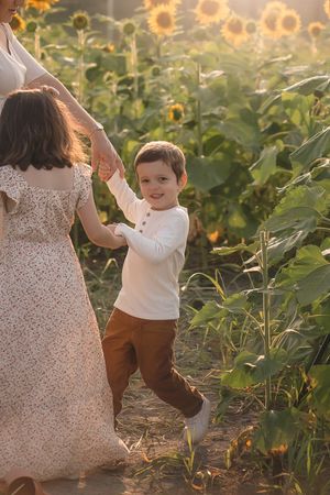 A candid moment captured in a sunflower field during golden hour with playful movement and warm light in the Hudson Valley,NY.