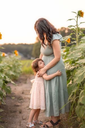 A touching embrace amidst towering sunflowers on a dirt path during golden hour in the Hudson Valley,NY.