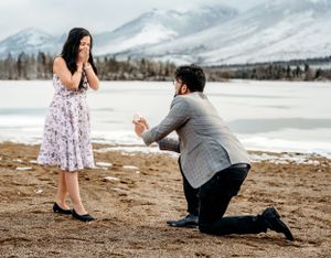 A surprise proposal moment captured against a snowy mountain landscape.