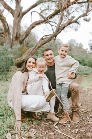 Family enjoying playful moments together on a nature trail surrounded by eucalyptus trees.