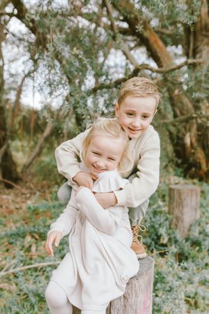 Candid moments of joy and laughter captured in a natural outdoor setting with trees in the background.