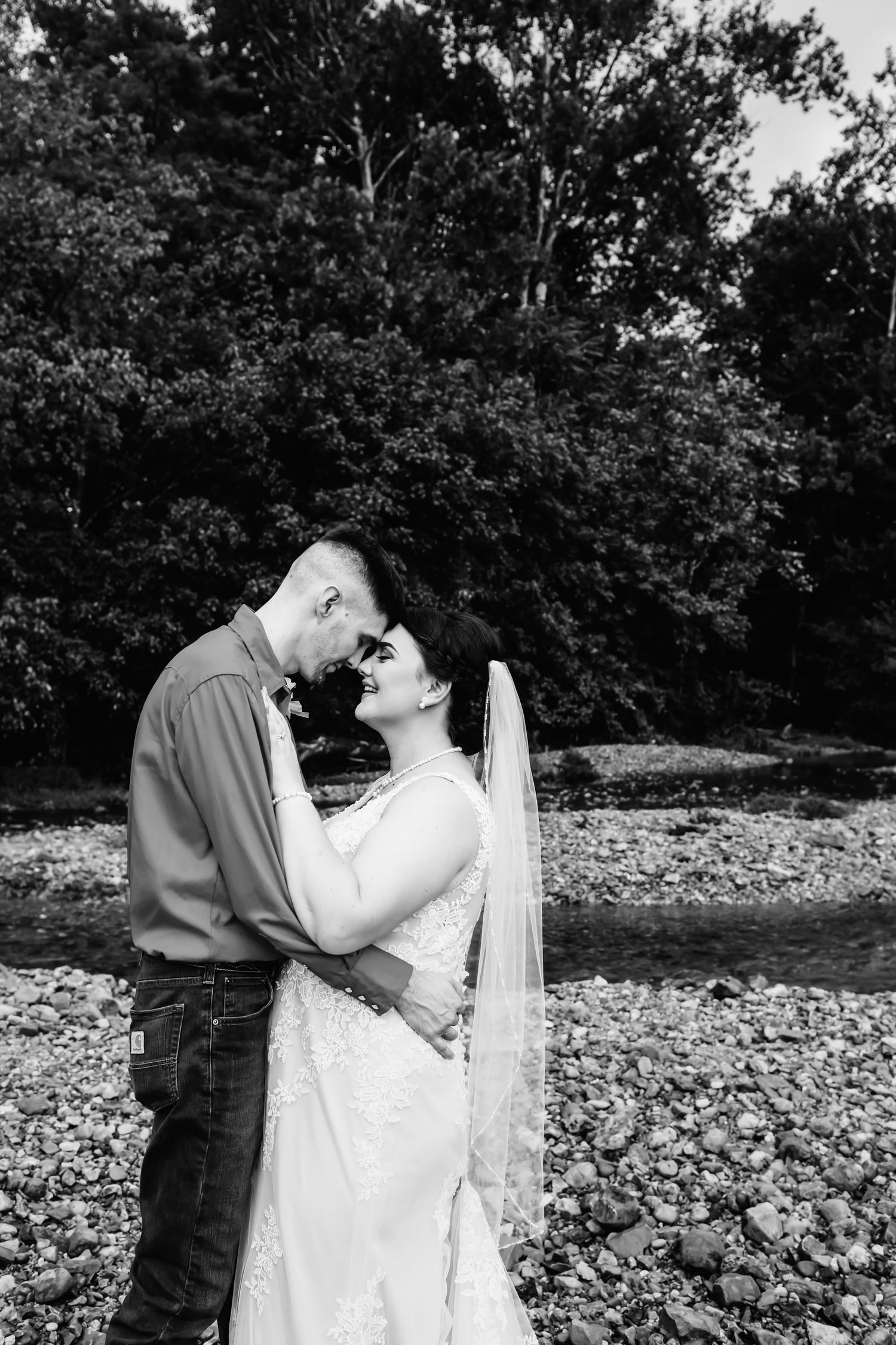 Bride and groom in black and white standing in creek bed in Dickson, TN