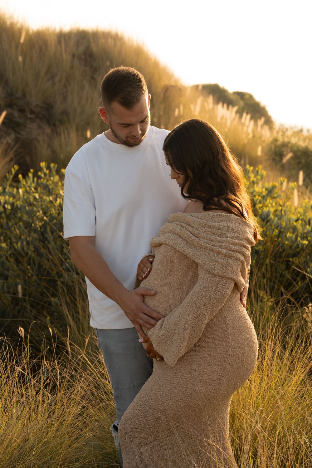 Maternity couple holding belly, captured in Wollongong.