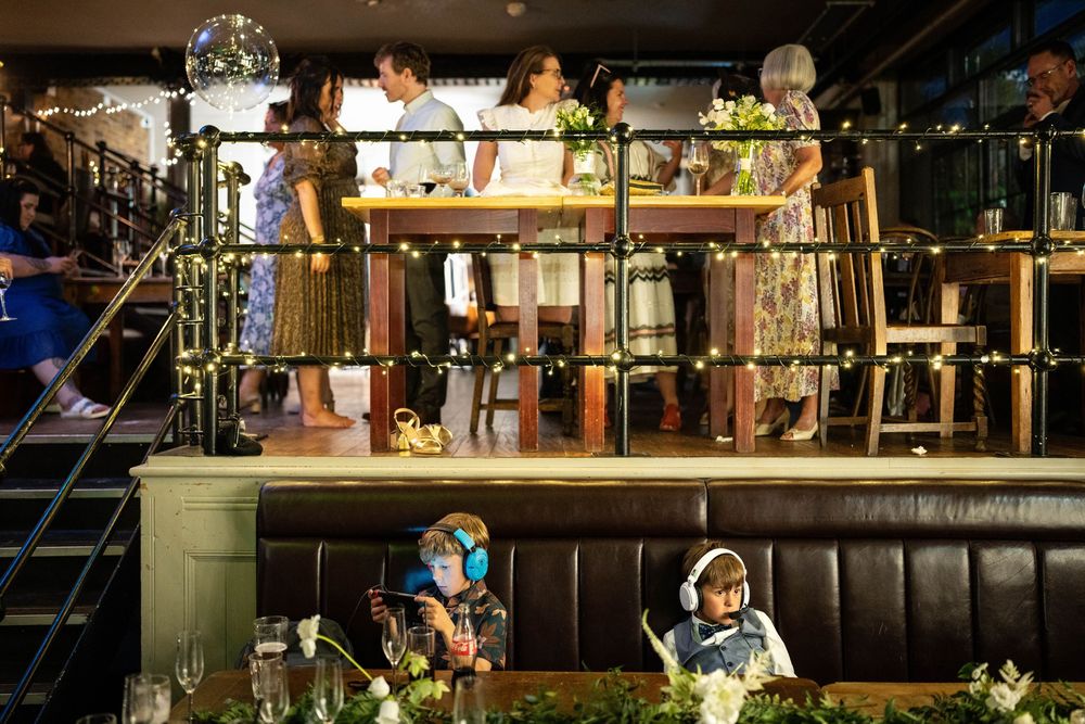 Dark restaurant interior with leather booth seating and industrial-style decor illuminated by warm lighting.