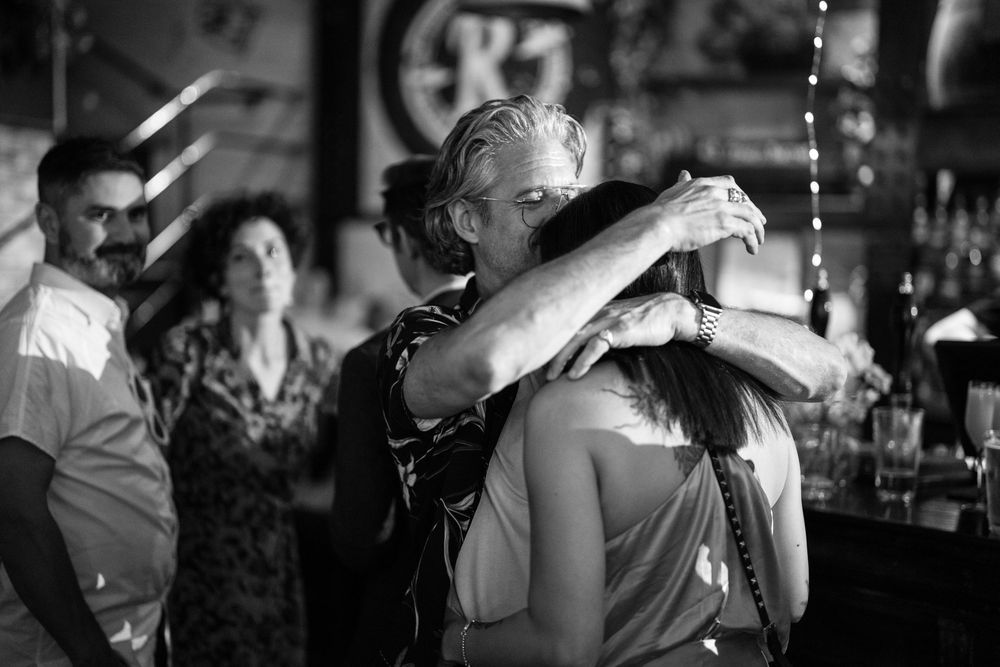 Dancing couples on a dimly lit dance floor in an intimate black and white scene.